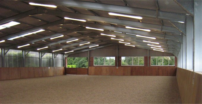 Interior view of steel-framed riding arena with windows providing lots of light